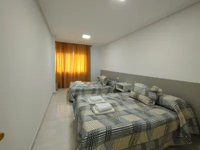 a hotel room with three beds and a couch at MARSÁN in Arzúa