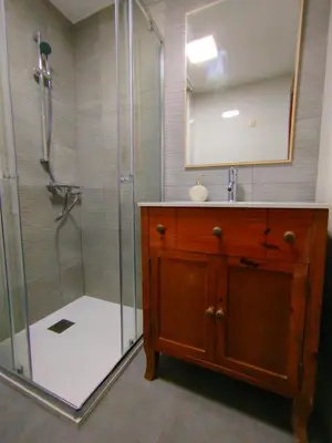 a bathroom with a shower with a sink and a mirror at MARSÁN in Arzúa