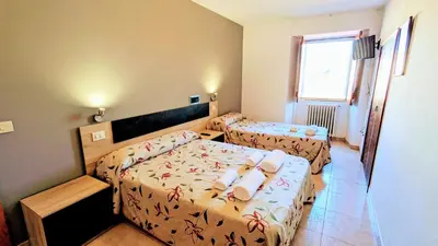 a small bedroom with two beds and a window at Restaurante y Hostal San Paio in Santiago de Compostela