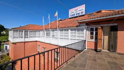 a building with a balcony with a sign on it at Restaurante y Hostal San Paio in Santiago de Compostela