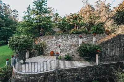 a stone retaining wall with a stone staircase at Torre do Rio in Caldas de Reis