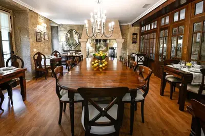 a dining room with a large wooden table and chairs at Torre do Rio in Caldas de Reis