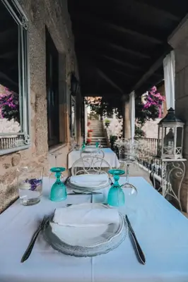 a table with blue plates and silverware on it at Torre do Rio in Caldas de Reis
