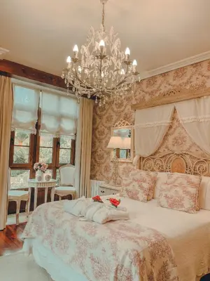 a bedroom with a large bed with a chandelier at Torre do Rio in Caldas de Reis