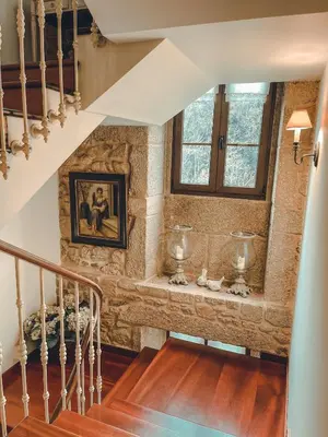 a staircase in a home with a stone wall at Torre do Rio in Caldas de Reis