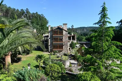 an image of a house with a river and trees at Torre do Rio in Caldas de Reis