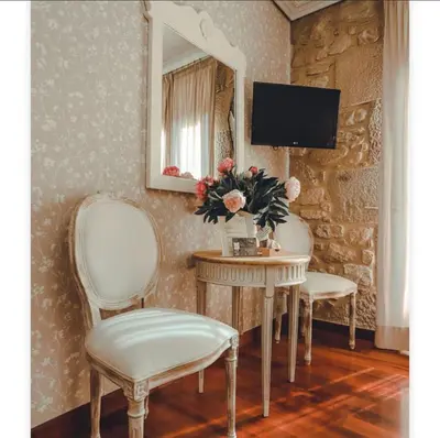 a room with two chairs and a table and a mirror at Torre do Rio in Caldas de Reis