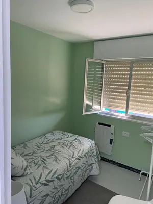 a bedroom with a bed and a window with shutters at VT Maria in Ribadeo