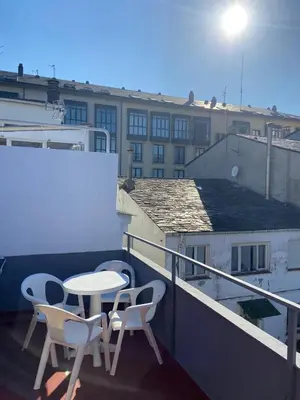 a balcony with a table and two chairs and a building at VT Maria in Ribadeo