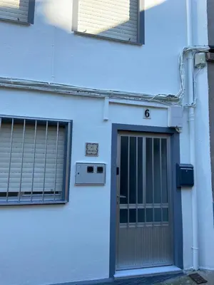 a white building with a door and two windows at VT Maria in Ribadeo
