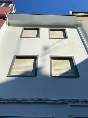 three windows on the side of a white building at VT Maria in Ribadeo