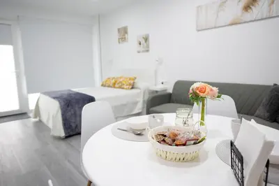 a room with a table with a bowl of food on it at Huna Apartamentos in Padrón
