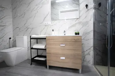 a bathroom with a sink and a toilet at Huna Apartamentos in Padrón