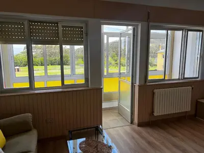 a living room with windows and a couch at APARTAMENTO FOZ Imr in Foz