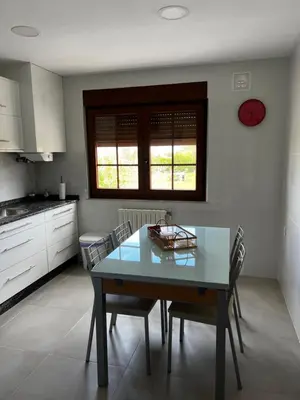 a kitchen with a dining room table and chairs at APARTAMENTO FOZ Imr in Foz