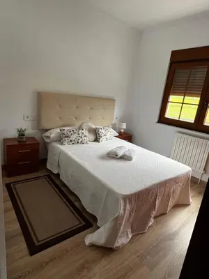 a bedroom with a large bed with white sheets and a window at APARTAMENTO FOZ Imr in Foz
