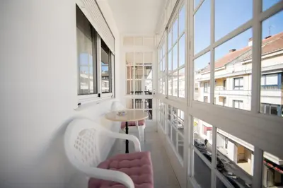 a room with a table and chairs and windows at Dulces Estancias in Lalín