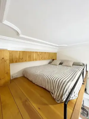 a bedroom with a bed in a room with wooden floors at Catapiriño - Confort Elegante y Exclusivo en el Corazón de la Ciudad in Ourense