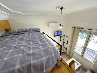 a bedroom with a bed in the corner of a room at Catapiriño - Confort Elegante y Exclusivo en el Corazón de la Ciudad in Ourense