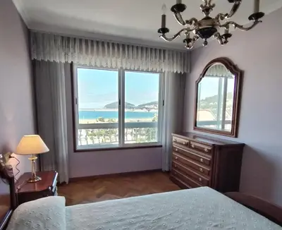 a bedroom with a bed and a large window at Sobre la Playa in Covas