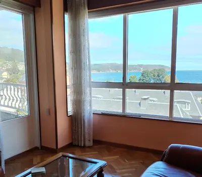 a living room with a large window with a view of the ocean at Sobre la Playa in Covas