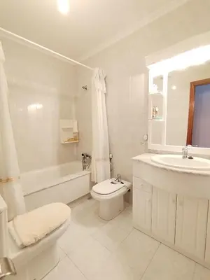 a white bathroom with a toilet and a sink at Sobre la Playa in Covas