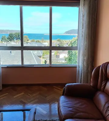 a living room with a couch and a large window at Sobre la Playa in Covas