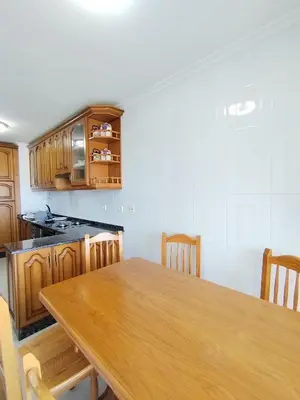 a kitchen with a wooden table and wooden cabinets at Sobre la Playa in Covas