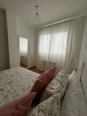 a bedroom with a bed with pillows and a window at Apartamento a pie de playa La Pepa in Burela de Cabo