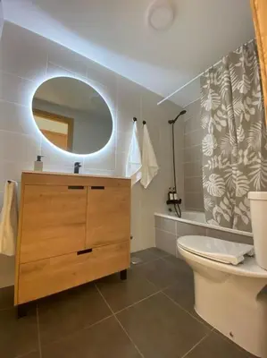 a bathroom with a sink and a toilet and a mirror at Apartamento a pie de playa La Pepa in Burela de Cabo