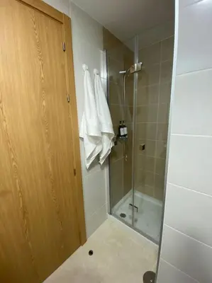 a bathroom with a shower and a glass door at Apartamento a pie de playa La Pepa in Burela de Cabo