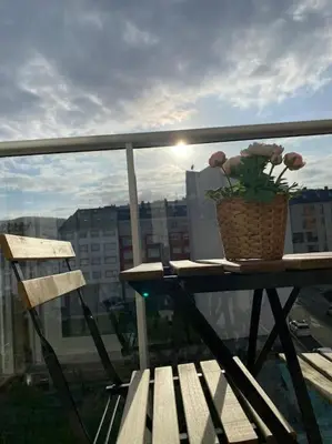 a table with a basket of flowers on a balcony at Apartamento a pie de playa La Pepa in Burela de Cabo