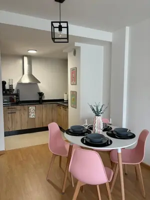 a dining room with a table and pink chairs at Apartamento a pie de playa La Pepa in Burela de Cabo