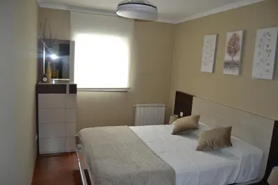 a bedroom with a white bed with a window at Ático Xacobeo 360 views in Sarria