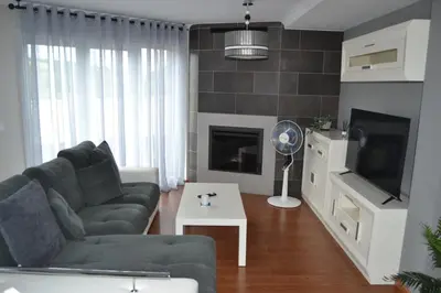 a living room with a couch and a tv at Ático Xacobeo 360 views in Sarria