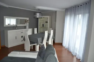 a dining room with a table and chairs and a mirror at Ático Xacobeo 360 views in Sarria