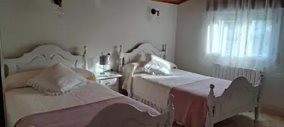 a white bedroom with two beds and a window at Casa Castrexa in Novoa