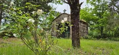 an old stone church with a cross in a field at Casa Castrexa in Novoa