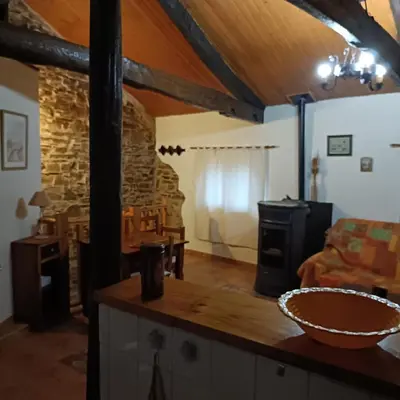 a kitchen and living room with a stone wall at Casa del agua in Espinoso de Compludo