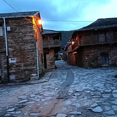 a cobblestone street in a village with buildings at Casa del agua in Espinoso de Compludo