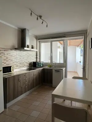 a kitchen with wooden cabinets and a table in it at Cuatro Calles Picarolas in Ribadeo