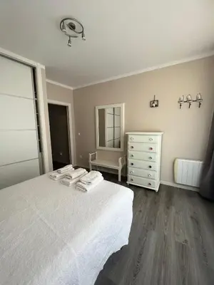 a bedroom with a white bed and a dresser at Cuatro Calles Picarolas in Ribadeo