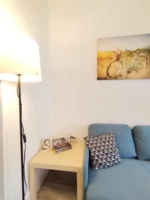 a living room with a blue couch and a table with a lamp at Yellow House in Viveiro