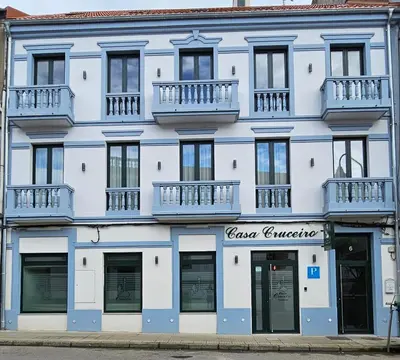 a blue and white building with windows and balconies at Pensión Casa Cruceiro in Arzúa