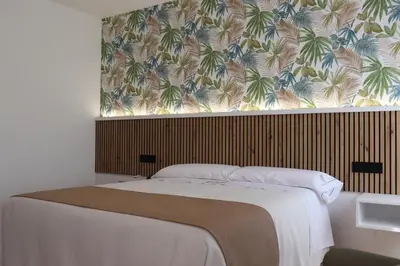 a bedroom with a bed with a tropical wallpaper at Pensión Casa Cruceiro in Arzúa