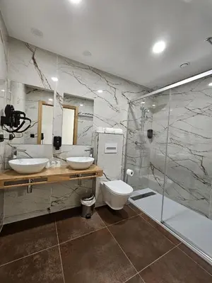 a bathroom with two sinks and a shower and a toilet at Pensión Casa Cruceiro in Arzúa