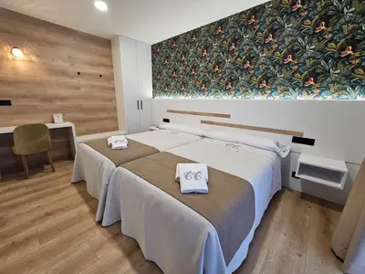 a bedroom with a large bed with towels on it at Pensión Casa Cruceiro in Arzúa
