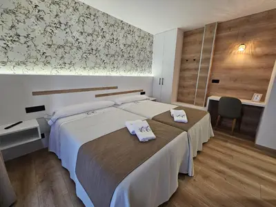 a bedroom with a large bed with towels on it at Pensión Casa Cruceiro in Arzúa