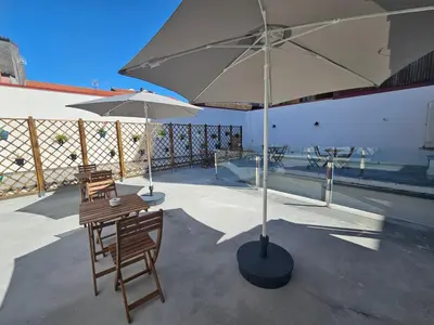 a patio with two tables and two umbrellas at Pensión Casa Cruceiro in Arzúa