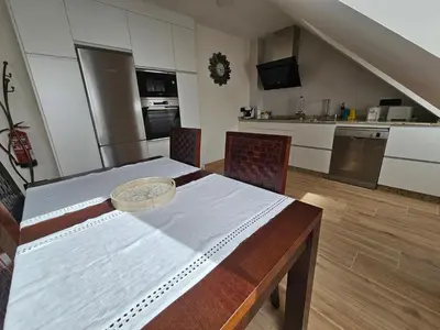 a kitchen with a wooden table and a dining room at Apartamento Casa Cruceiro in Arzúa